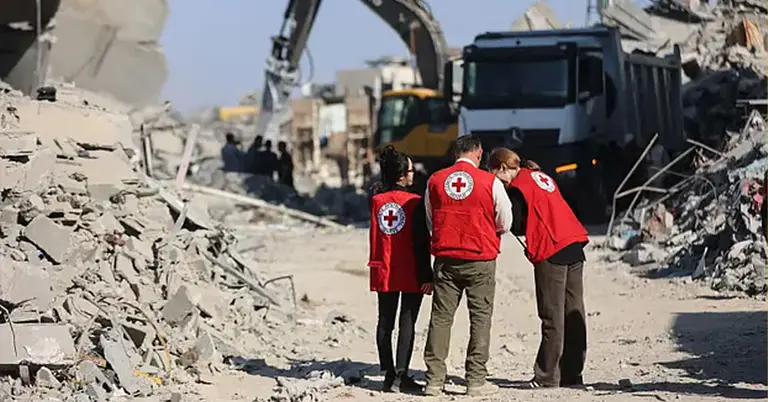 যুদ্ধে ধ্বংস হয়ে যাওয়া ভবনের সামনে রেডক্রসের সদস্যরা